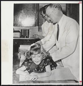 Polio Experiment--Patricia Ann Burnett, five-year-old daughter of Dr. Matthew Burnett of Houston, Tex., polio advisor to the Harris County Polio Association, received first shot in experiment to fight paralysis from polio with gamma globulin, a blood faction in a mass inoculation of children one to six in polio plagued Houston. Dr. Byron York administers the shot.
