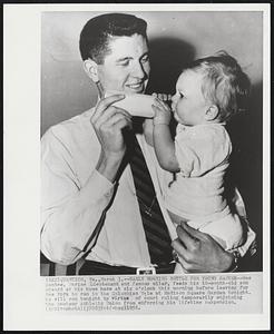 Early Morning Bottle for Young Santee--Wes Santee, Marine Lieutenant and famous miler, feeds his 10-month-old son Edward at his home here at six o'clock this morning before leaving for New York to run in the Columbian Mile at Madison Square Garden tonight. He will run tonight by virtue of court ruling temporarily enjoining the Amateur Athletic Union from enforcing his lifetime suspension.