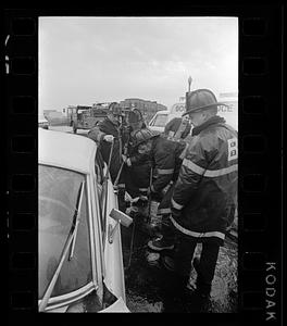 Firemen pry open door of car after accident, Jamaicaway