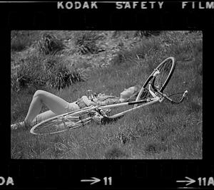 Person and bicycle lying in grass