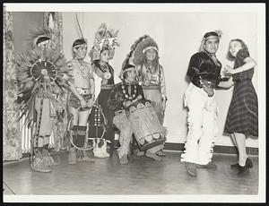 Indians - Dance Hopi Canter, Qua - Haf - Tewa, learns a Conga step with Miss Florence Gerrish, of Montgomery, Ala., teacher at Arthur Murray Studio at Hotel Statler as Hopi dancers from Arizona look on. Hopis have arrived in Boston for the Sportsmen's Show.