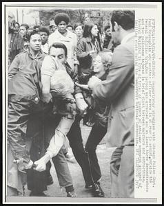 Demonstrator struggles with Chicago Police Capt. Paul McLaughlin and another officer moves in at rear to assist, outside the Federal Building 9/24. One person was arrested and at least three demonstrators and two policemen injured in brief clash between marchers and authorities. Federal Building in site of trial of leaders of anti-war movement accused of inciting riots during the Democratic National Convention.