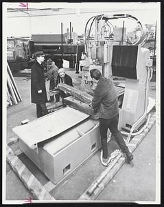 Moving Time for this 31,000 pound profile milling machine in preparation for the N. E. Industrial Show. G. William Terry, left, vice president, Boston Machinery, Inc. supervises workmen unloading the unit to be displayed.