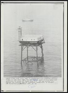 Lightship's Days Numbered--Resting firmly on four steel legs, the new Ambrose Light Station makes its appearance 7.4 miles off Sandy Hook, N. J. The new station will replace the historic Ambrose lightship, background, in October.