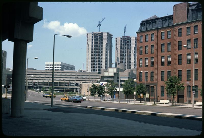 Cranes above skyscrapers being built, street in foreground