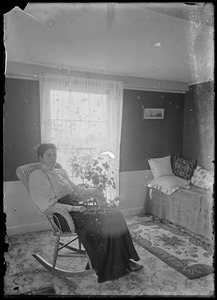 Woman in wicker chair, interior
