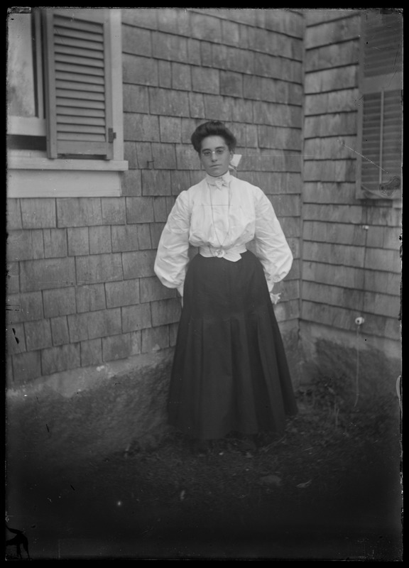Woman at angle of house outdoors