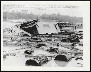 Debris on flooding Willamette river comes to ground on Swan Island near downtown area. River crested here Christmas day at 29.8 feet.