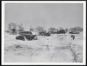 Snow-Bogged Cars -- A wrecker was needed to haul these cars from out of snow drifts in the Carson Beach area of South Boston during yesterday’s wild snow storm. The scene was familiar in many areas of New England as motorists had to abandon cars.
