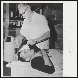 Pittsburgh Pirates' Trainor Charles Jorgensen gives first aid treatment to Dee Fondy, Pittsburgh first baseman. He was struck by thrown ball in pregame practice in St. Louis. Fondy suffered hemorrhage of the left eye and a broken nose.