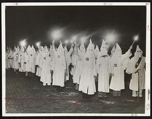Warn Negro Voters. Marching along bearing fiery torches Ku Klux Klan members demonstrated to warn against meddling with the Negro vote in municipal elections here yesterday.