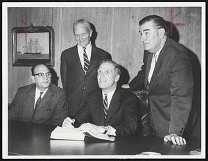 Mayor White, with pen in hand, yesterday signed contract for modernization plan at Boston City Hospital. With mayor are, left, Dr. Andrew P. Sackett, seated, Howard Buckley and William H. Ellis Jr.