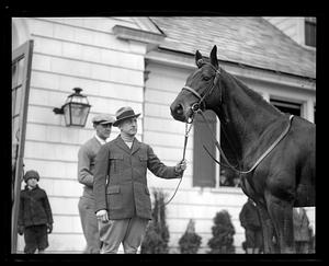 Unidentified man holding the reins of a horse