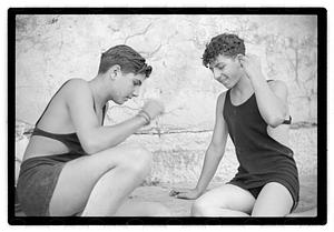 Two unidentified young men playing rock scissor paper
