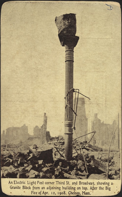 An electric light post corner Third St. and Broadway, showing a granite block from an adjoining building top. After the big fire of Apr. 12, 1908. Chelsea, Mass.