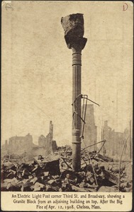 An electric light post corner Third St. and Broadway, showing a granite block from an adjoining building on top. After the big fire of Apr. 12, 1908. Chelsea, Mass.