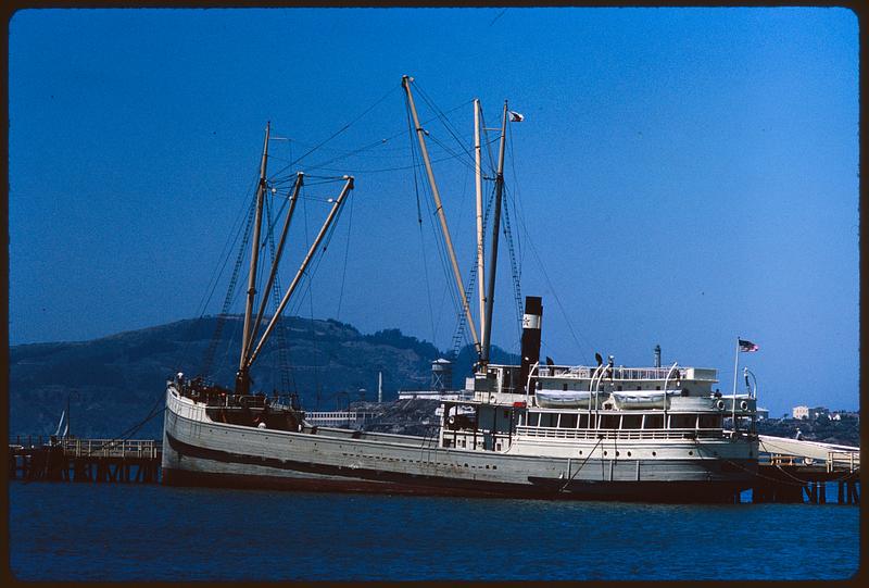 Boat at pier with hills in background. San Francisco Maritime Museum