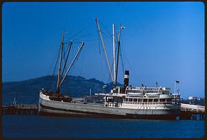 Boat at pier with hills in background. San Francisco Maritime Museum