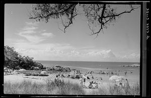 View of beach with beachgoers, some in the water, Cape Ann