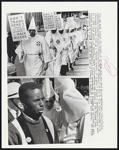 Members of the Ku Klux Klan, referred to by President Johnson 3/26 as a “hooded society of bigots,” picket a desegregated hotel here in a 1964 file photo. At bottom, a Negro youth, wearing the button of the Student Non-violent Coordinating Committee (SNCC),is almost surrounded by Klansmen as he tries to gain admittance to a park in which the Klan is holding a rally, in a 1964 file photo.