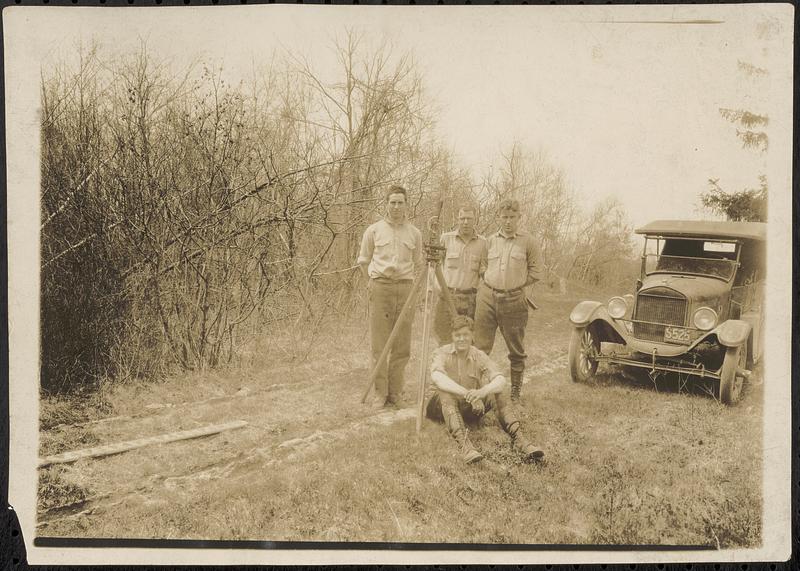 View of surveying engineers, with a surveying level and their state vehicle, likely in the Swift River Valley, the area that would become the Quabbin Reservoir, Mass., ca. 1928