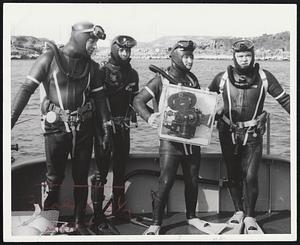 Ready to film underwater sequences off Bermuda for Air Force movie is Airman Michael Welby (with camera. photo at right) and civilian divers Al Cristoforo, Art Geddes and Don Conroy, all of Hanscom Field, Bedford. Welby (photo below) tows waterfight movie camera after surfacing from Hanscom - built SUBA sub. Two of the subs performed in Bermuda's crystal-clear waters for film depicting capabilities of two surplus wing tanks converted to make underwater searches faster and easier. SCUBA subs are transported in cargo planes.