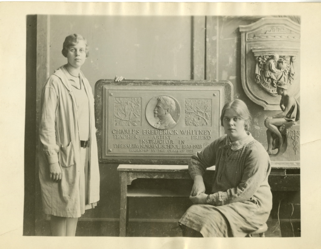 Two students with plaque memoralizing Charles Frederick Whitney