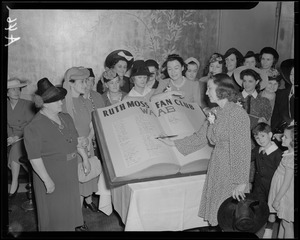 Unidentified woman signs oversize Ruth Moss Fan Club register
