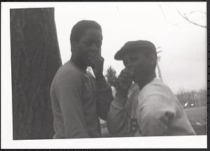 Two boys covering their mouths with their hands