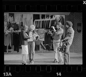 Market researcher interviews customers at shopping mall in Brighton