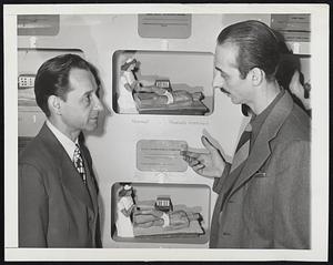 Two men examine physical therapy display