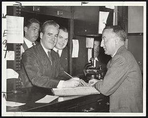 Enters Race - Mayor John E. Kerrigan at the election commission office today signing his application papers as candidate for Mayor in the November election.