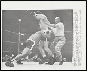 Patterson Hangs On-- This is the second knockdown suffered by heavyweight champion Floyd Patterson in the first round of last night's title bout with Ingemar Johansson at Miami Beach. After the fight Patterson, who retained the title with a sixth round knockout, said the mandatory eight count helped him to recover after each knockdown. Referee is Billy Regan.