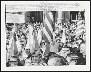 Hooded Ku Klux Klan members marched in a rally supporting U.S. policy in Vietnam 11/7.The march, which brought an estimated 2,000 onlookers, turned into a pep rally as University of Texas students mobbed around the clansmen singing and yelling football cheers.