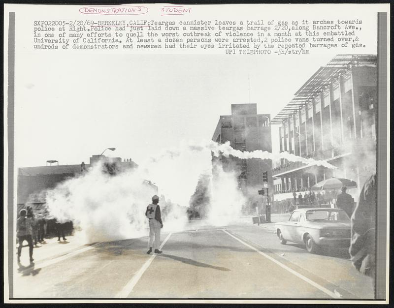 Berkeley, Calif: Teargas cannister leaves a trail of gas as it arches towards police at Right. Police had just laid down a massive teargas barrage 2/20, along Bancroft Ave., in one of many efforts to quell the worst outbreak of violence in a month at this embattled University of California. At least a dozen persons were arrested, 2 police vans turned over & undreds of demonstrators and newsmen had their eyes irritated by the repeated barrages of gas.