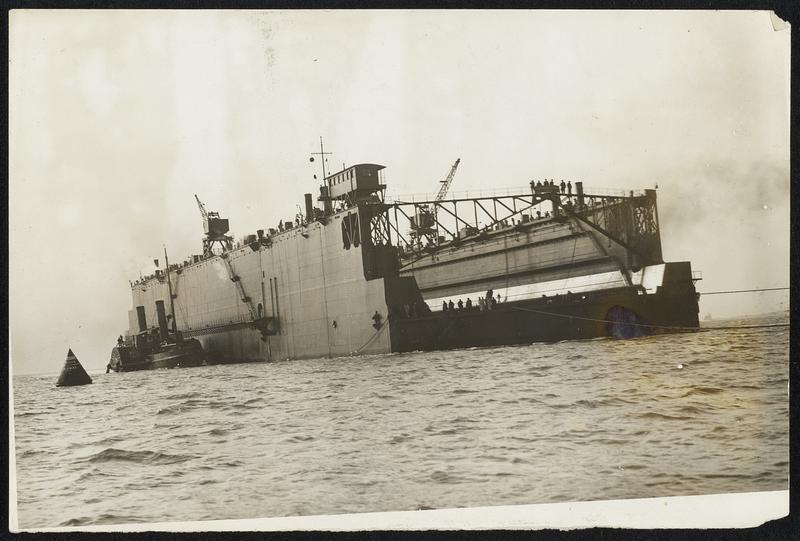 The Largest Floating Dock in the World. On the morning of August 22nd the huge floating dock which is to constitute such a valuable addition to the docking accommodation of warshi at Portsmouth was towed into Portsmouth Harbour by 4 powerful tugs. The dock left Birkenhead a week previously where it had been constructed by Messrs. Cammell Laird & Co., and arrived after a very rough voyage. The dock was ordered in 1909 and is the largest in the world. Its length over all is 700 feet and 680 feet over the blocks. Its width at the entrance is 150 feet and it has a lifting capacity of 4,000 tons,so that it will be able to dock the largest Super-Dreadnought yet built or designed. This photo shows the huge dock being towed into Portsmouth Harbour.