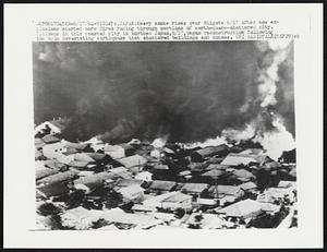 Heavy smoke rises over Niigata 6/17 after new expansions started more fires racing through sections of earth-quake-shattered city. Citizens in this coastal city in northen Japan, 6/17, began reconstruction following the 6/16 devastating earthquake that shattered buildings and houses.