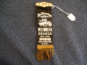 Black ribbon with white lettering and gold fringe