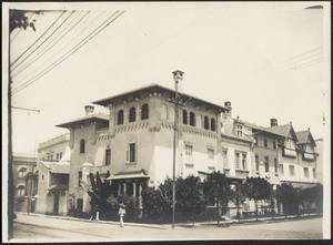 Corner view of 3-story building, people walking in foreground