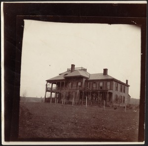 View of large house with porch and widows walk; fenced in chicken run in front