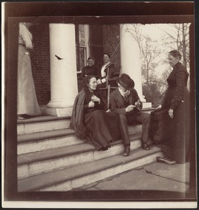 Joseph Randolph Coolidge sitting on front porch steps of Georgian-style brick house with five women