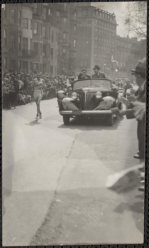 A car drives alongside a runner in a race