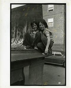 Two children sitting on the back of a dump truck