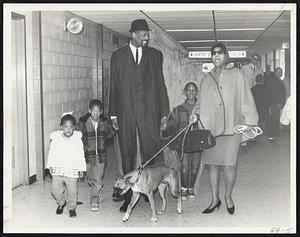 Royal Greeting Home is given Celtics’ center Bill Russell, met at Logan Airport by, left to right, daughter Karen, sons Jacob and Bill Jr., wife, Rose, and pet boxer, Booma, upon arrival late yesterday afternoon.