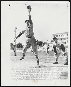 Schoendienst Tries First -- Infielder Red Schoendienst of the St. Louis Cardinals, one of baseball's top second basemen, works out at first base here today. Watching the red head closely is Manager Eddie Stanky, himself a star second sacker, who is fine combing his squad for a first string first baseman.