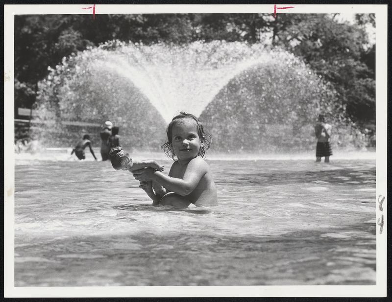 On Boston Common, Lorraine Bartone, 18 months, treats her doll to a dip in the Frog Pond