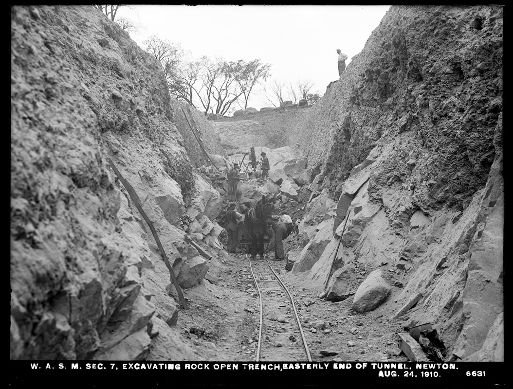 Distribution Department, Weston Aqueduct Supply Mains, Section 7, excavating rock open trench, easterly end of tunnel, Newton, Mass., Aug. 24, 1910