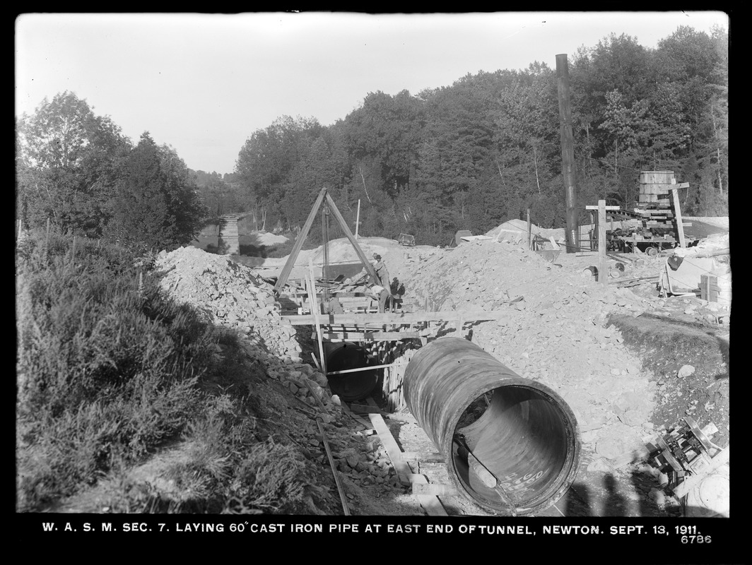 Distribution Department, Weston Aqueduct Supply Mains, Section 7, laying 60-inch cast-iron pipe at east end of tunnel; Cochituate Aqueduct, ventilator in background, left center, Newton, Mass., Sep. 13, 1911