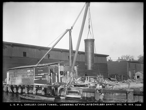 Distribution Department, Low Service Pipe Lines, Chelsea Creek Tunnel, lowering 42-inch pipe into Chelsea shaft, Chelsea, Mass., Dec. 18, 1914