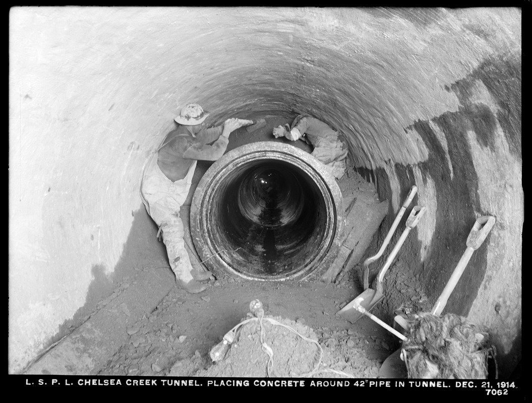 Distribution Department, Low Service Pipe Lines, Chelsea Creek Tunnel, placing concrete around 42-inch pipe in tunnel, Chelsea, Mass., Dec. 21, 1914
